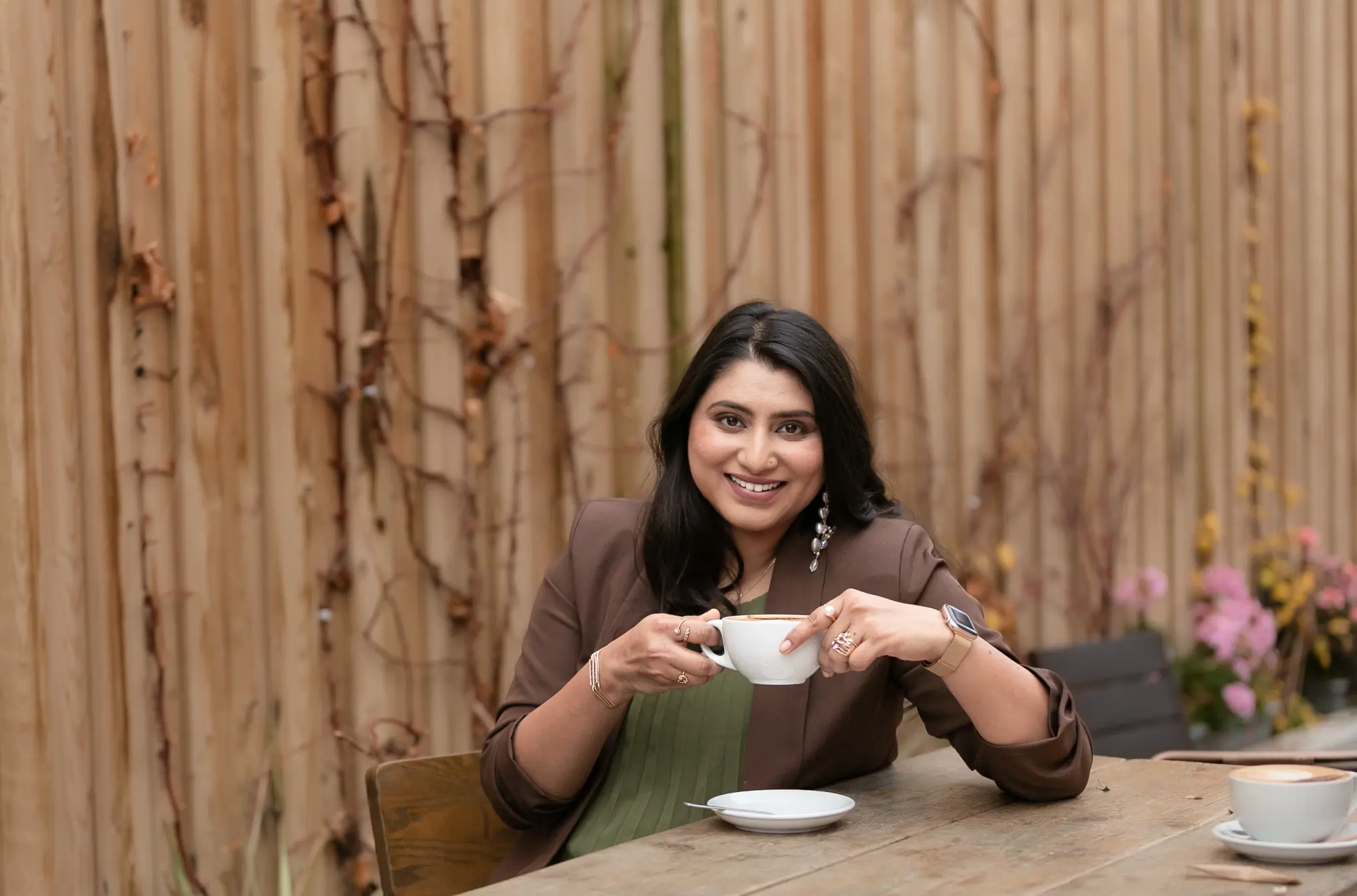Kriti, founder of Nukrition, at a wooden table with a coffee